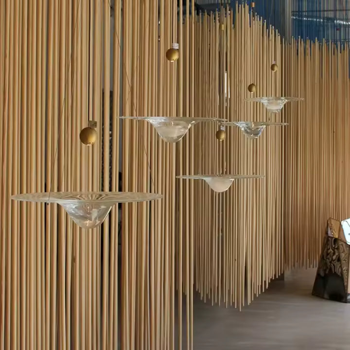Suspensions disque en verre à cœur goutte devant un décor en bois, au style japandi organique et aérien