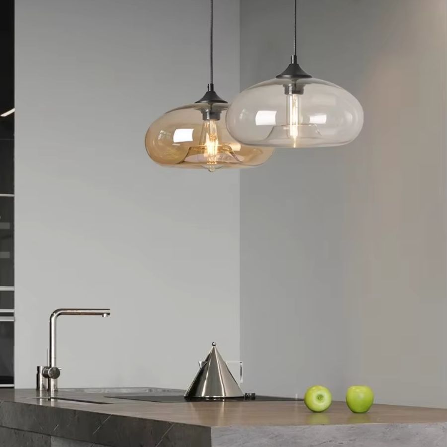 En duo au-dessus d’un îlot, ces suspensions dôme en verre ambré et transparent mêlent design rétro et contemporain