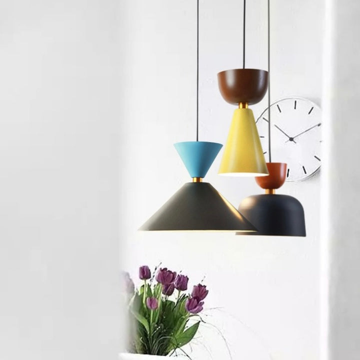 Ensemble de suspensions en métal coloré surplombant un meuble fleuri, pour une décoration d'intérieur fraîche et artistique.