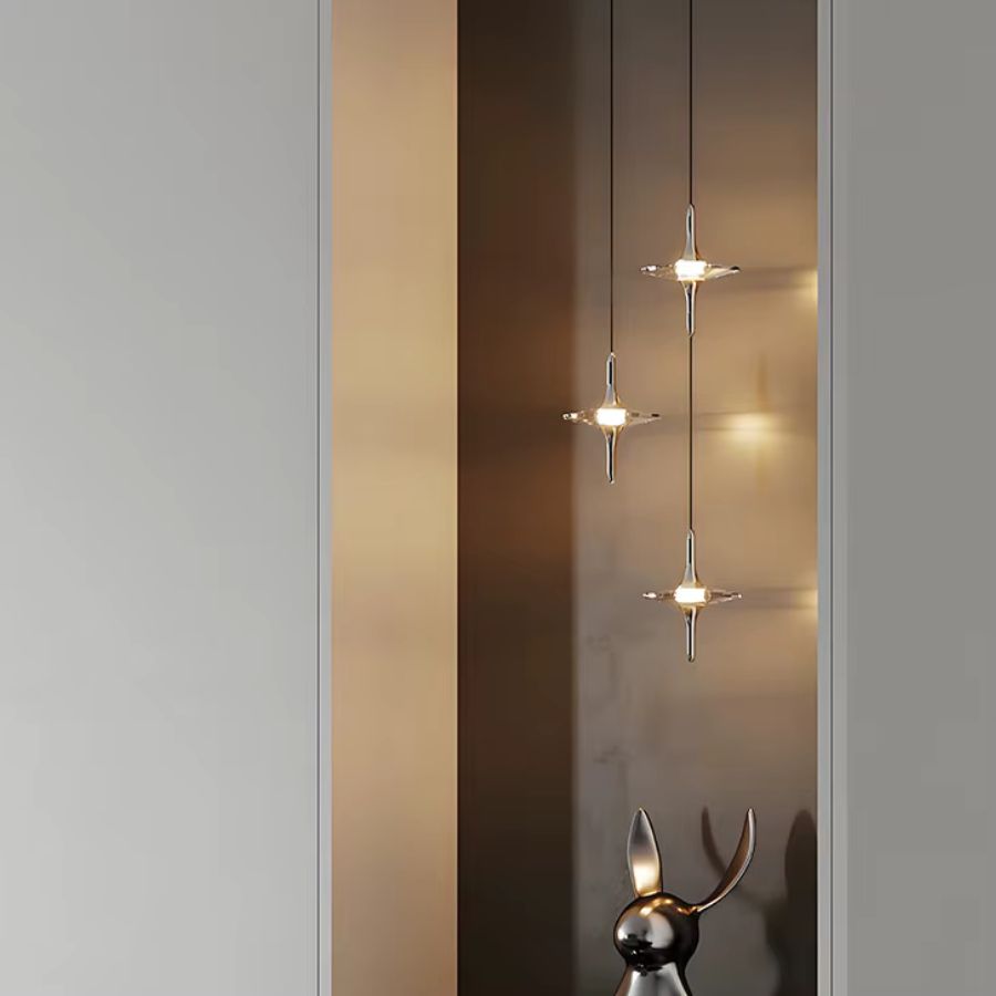 Trio de suspensions étoile en cristal K9 et métal chromé dans une entrée élégante au style contemporain et minimaliste