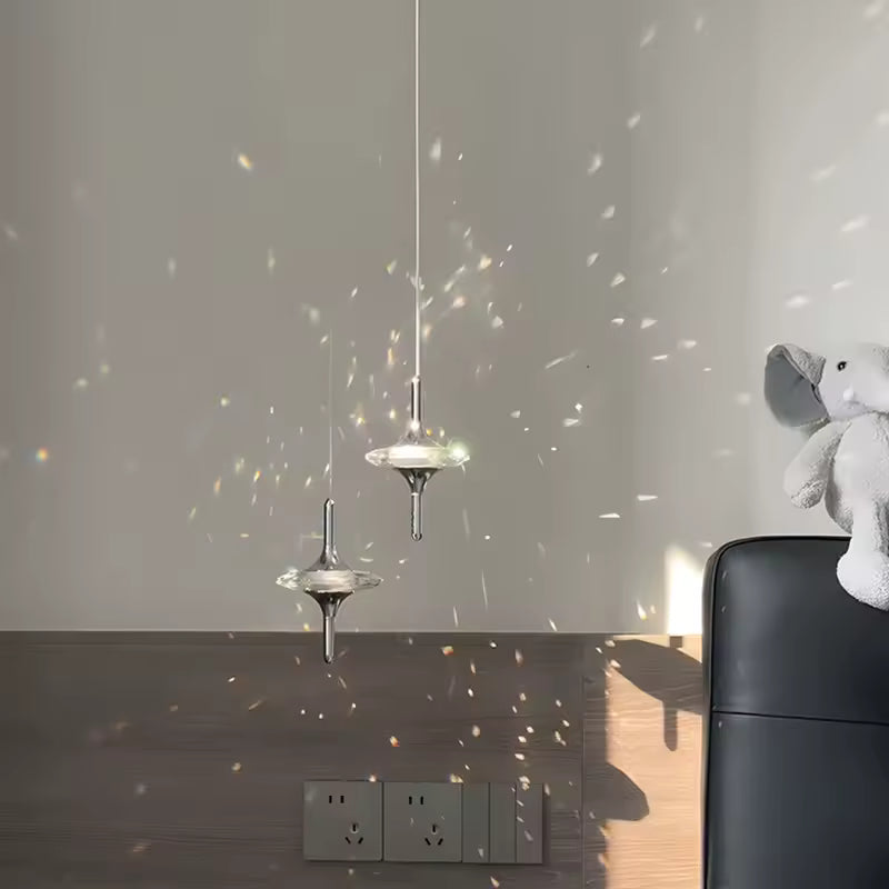 Deux suspensions étoile en cristal K9 et métal chromé projetant des reflets lumineux, dans un décor contemporain raffiné
