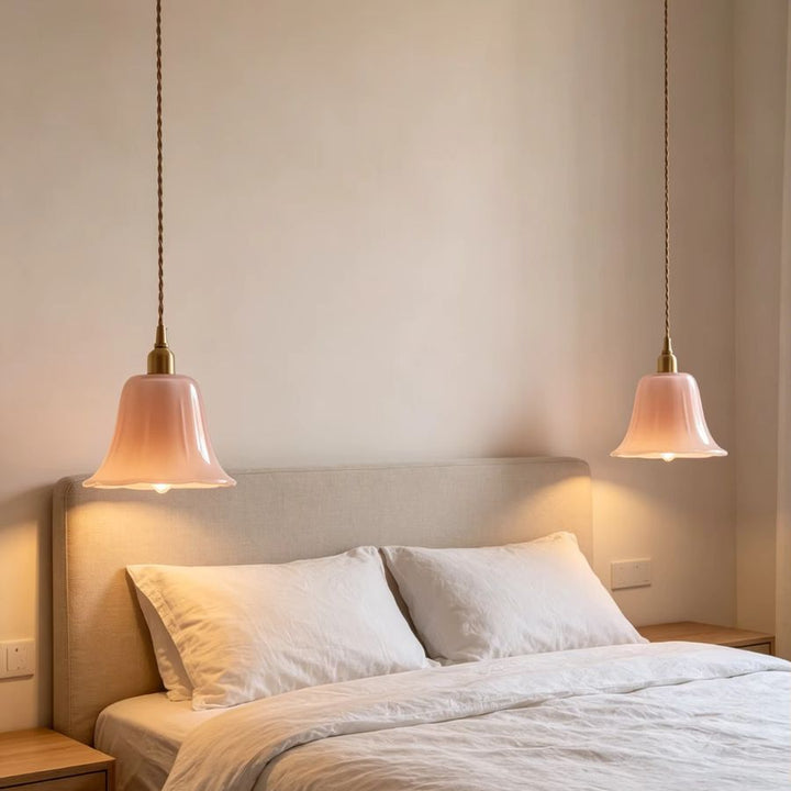 Deux suspensions fleur en verre rose diffusent une lumière douce dans une chambre au style vintage romantique
