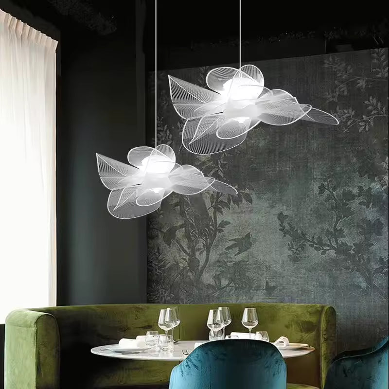 Deux suspensions fleurs blanches aux pétales aériens, style sculptural et moderne au-dessus d’une table de restaurant