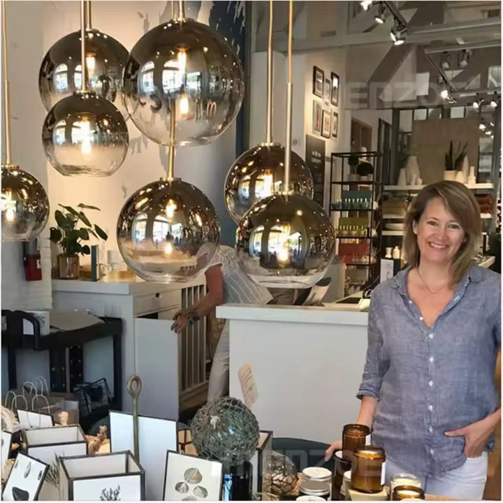 Plusieurs suspensions à globes en verre fumé et détails dorés, dans un décor chic aux accents vintage