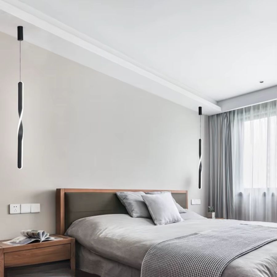De chaque côté du lit, deux suspensions noires torsadées structurent une chambre moderne au décor épuré