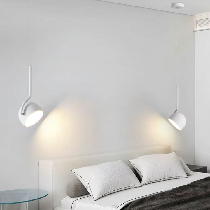 Deux suspensions blanches à coupole orientable encadrant le lit dans une chambre minimaliste et contemporaine