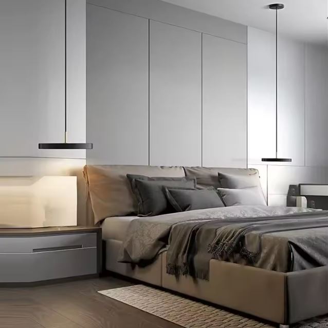 Deux suspensions plates noires éclairant une chambre moderne avec un lit confortable et une décoration minimaliste et élégante.