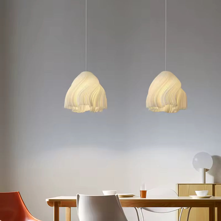 Duo de suspensions sculpturales aux plis ondulés dans une salle à manger moderne au décor épuré