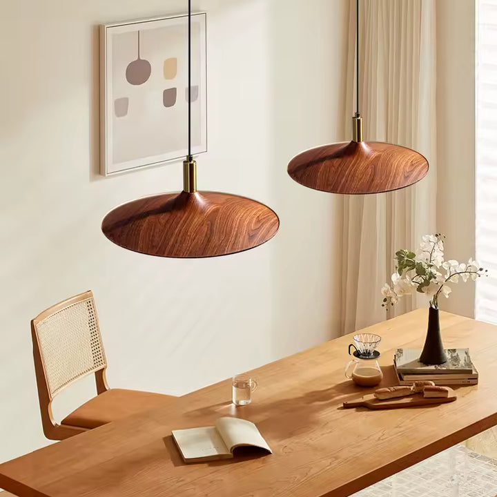 Deux suspensions soucoupe effet bois au-dessus d’une table, design scandinave aux lignes organiques