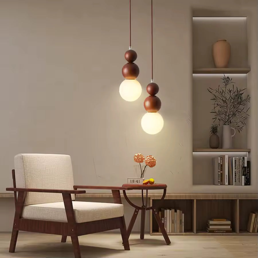 Duo de suspensions totem en bois à globe opalin, dans un salon chaleureux aux influences japandi et organiques