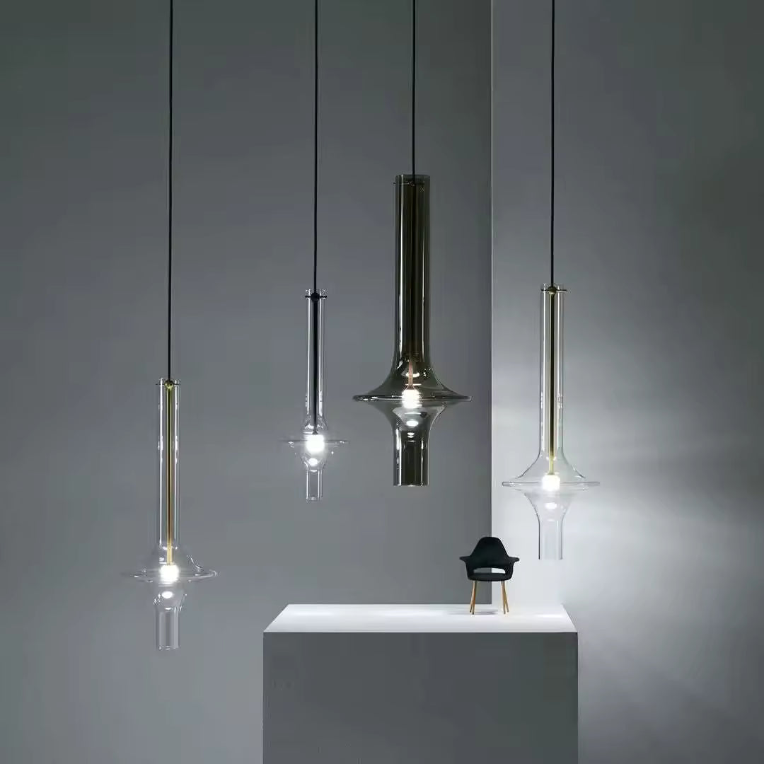 Suspensions totem en verre fumé et transparent aux silhouettes élancées, dans une composition minimaliste et sculpturale