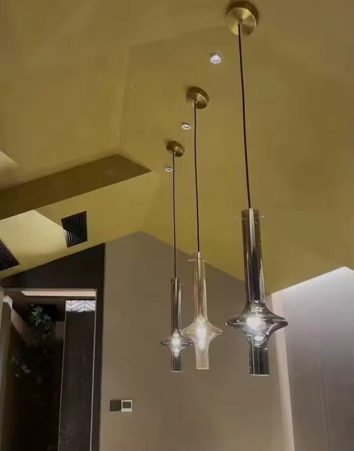 Trois suspensions totem en verre suspendues à différentes hauteurs, au style design et sculptural