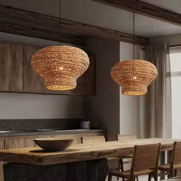 Deux suspensions tressées en fibre naturelle aux volumes sculpturaux, dans une salle à manger chaleureuse et rustique