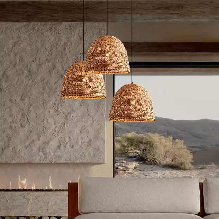 Trois suspensions tressées en fibre naturelle au style organique, dans un intérieur minéral aux tons chaleureux