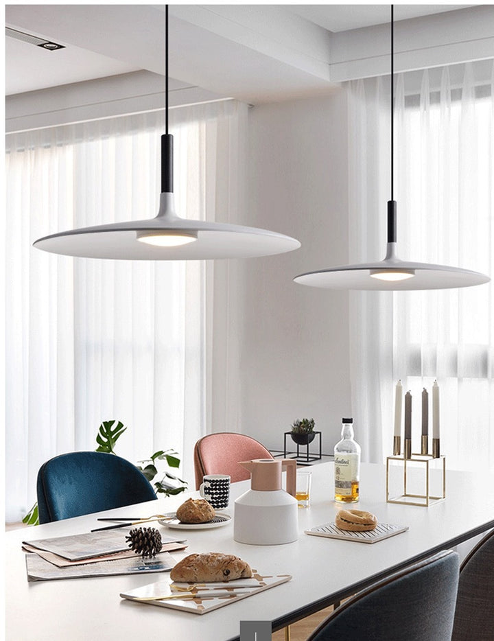 Suspensions UFO doubles installées au-dessus d'une grande table de réception décorée.