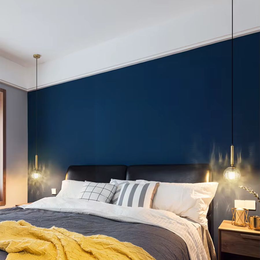 Deux suspensions en verre installées de chaque côté du lit, au design minimaliste et élégant pour une chambre contemporaine