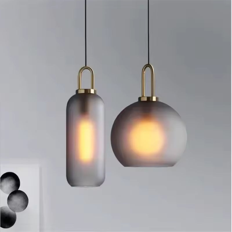 Duo de suspensions en verre fumé à anse dorée, associant forme globe et cylindre dans un style design raffiné
