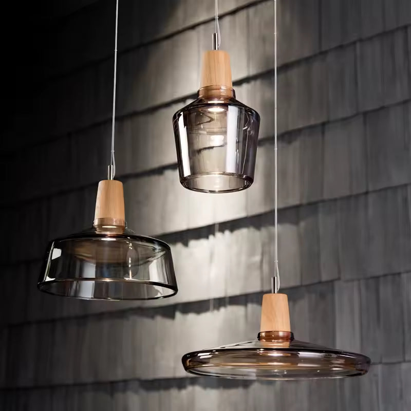 Composition de luminaires en verre fumé et bois aux formes sculpturales, dans un décor contemporain