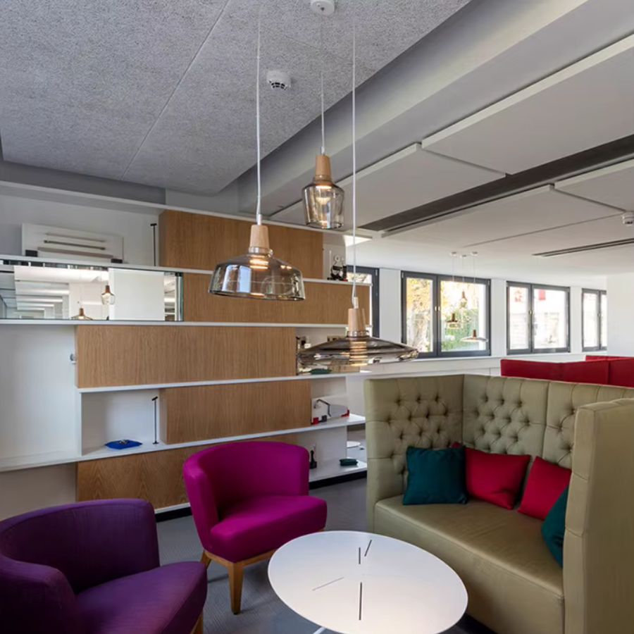 Dans un intérieur contemporain, trois suspensions en verre fumé et bois mêlent lignes épurées et formes organiques