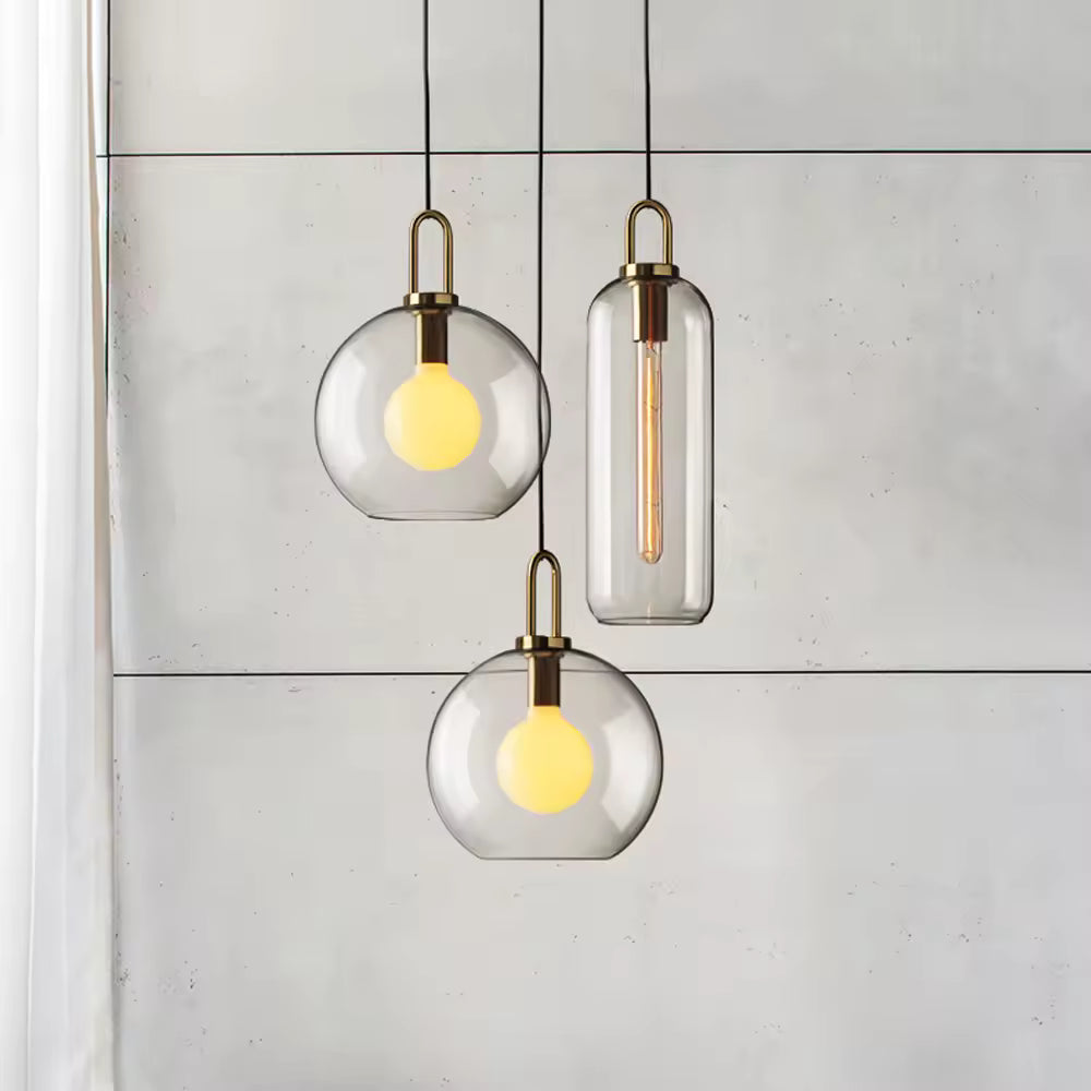 Ensemble de suspensions en verre transparent à anse dorée, mêlant formes globe et cylindre au style contemporain