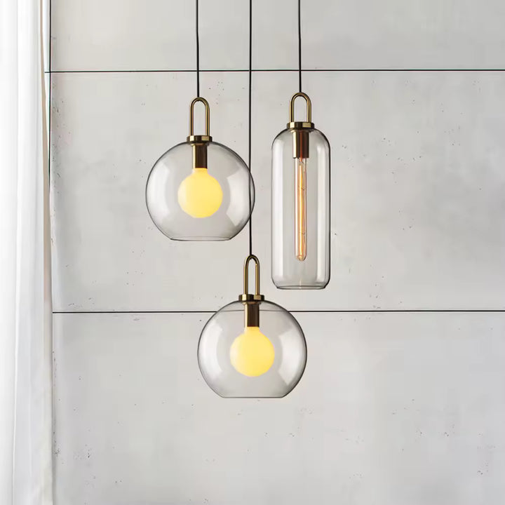 Ensemble de suspensions en verre transparent à anse dorée, mêlant formes globe et cylindre au style contemporain