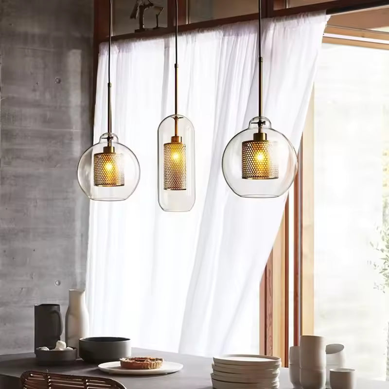 Trio de suspensions en verre transparent avec diffuseur doré ajouré, au style industriel chic et contemporain