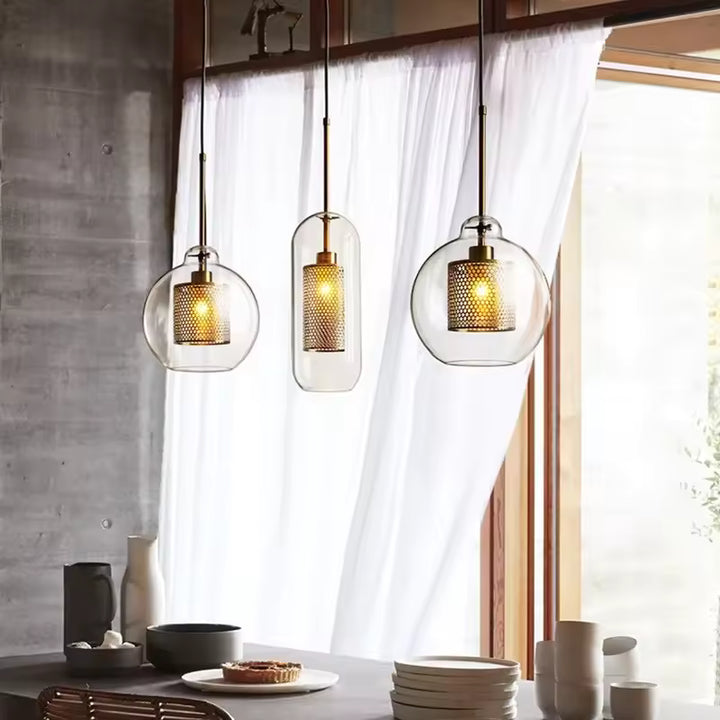 Trio de suspensions en verre transparent avec diffuseur doré ajouré, au style industriel chic et contemporain