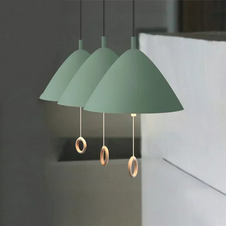 Alignement de suspensions vertes de style danois suspendues dans une cuisine moderne.