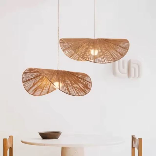 Duo de suspensions Vertigo en rotin, style scandinave, éclairant une table minimaliste pour une ambiance chaleureuse.