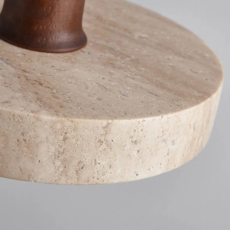 Zoom sur la texture granuleuse et authentique du travertin de l'abat-jour pour luminaire suspendu