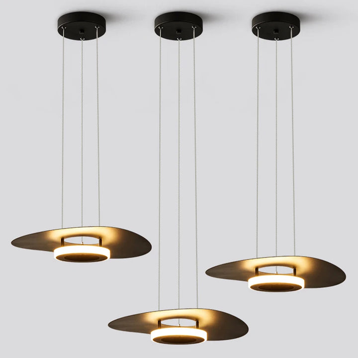 Trio de suspensions disque flottant noir avec éclairage LED diffus dans un espace ouvert.