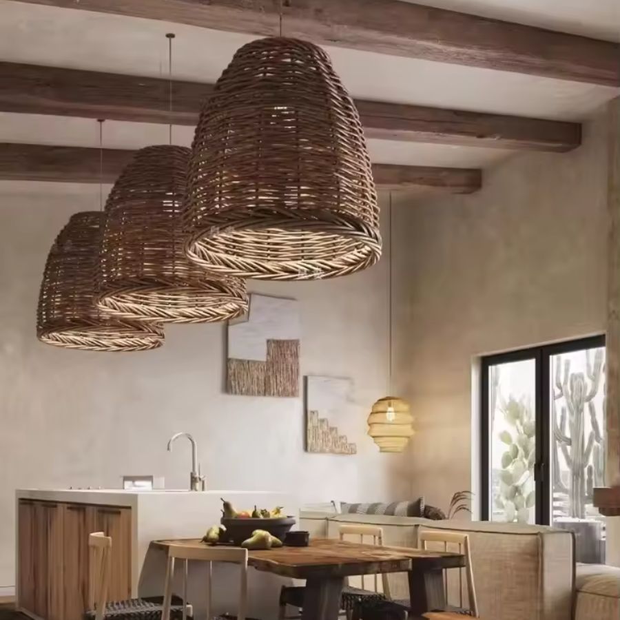 Trois suspensions en osier tressé forme cloche dans une salle à manger chaleureuse aux accents méditerranéens