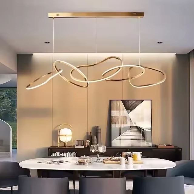 Suspension design italien haut de gamme avec des lignes fluides dorées, parfaite pour illuminer une salle à manger moderne et élégante.