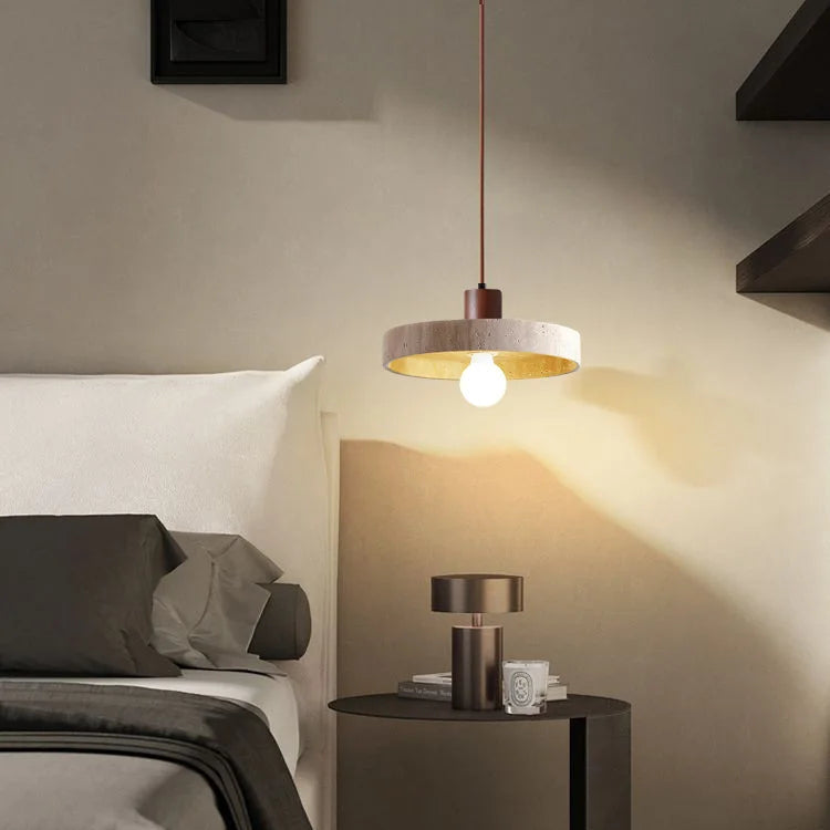 Vue d'ambiance d'une chambre minimaliste avec une suspension en pierre naturelle suspendue près du lit.