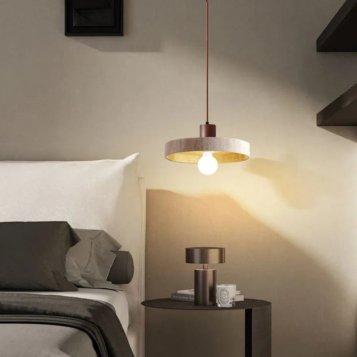 Vue d'ambiance d'une chambre minimaliste avec une suspension en pierre naturelle suspendue près du lit.