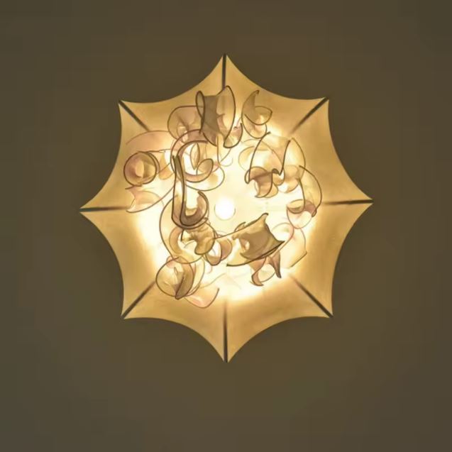 Vue de dessous d’une suspension méduse blanche, avec filaments ondulés et allure organique très poétique.