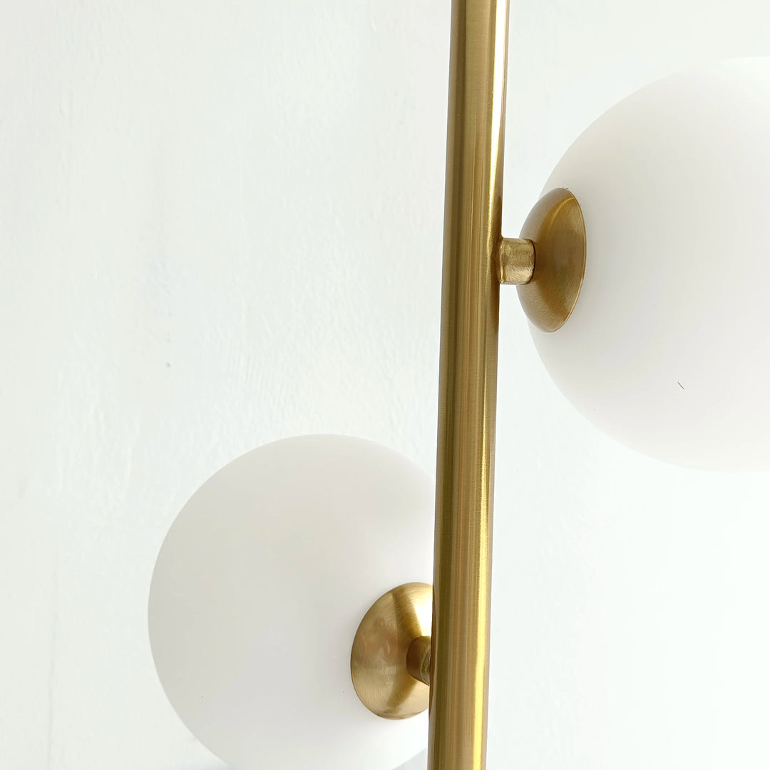 Vue rapprochée sur les globes lumineux LED fixés sur la structure tubulaire dorée.