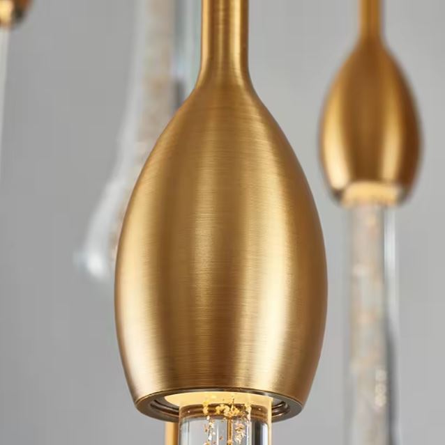 Zoom sur la finition brossée en laiton doré d’une goutte lumineuse, révélant le raffinement et la qualité de la suspension LED.