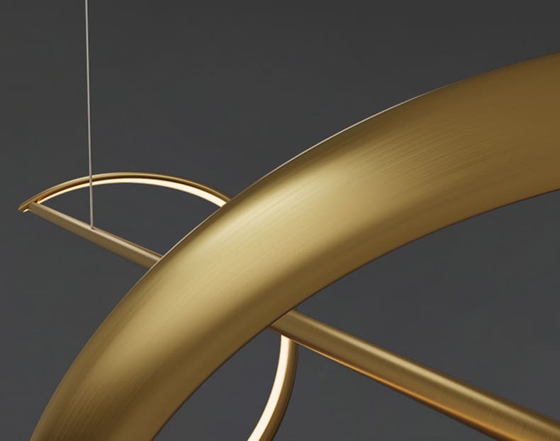 Zoom sur la texture du métal doré d'une suspension à ruban ondulé aux finitions soignées.